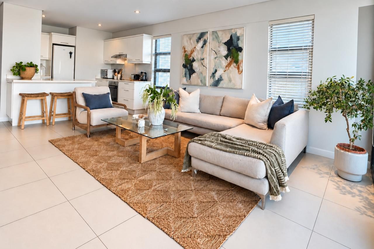 Airhost apartment lounge with jute rug and open-plan kitchen
